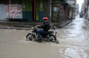 A Palestinian man rides his a bike through a rain flooded street at the Shati refugee camp in Gaza City, Sunday, Jan. 30, 2011. Photo by Mohammed Othman/Flash90